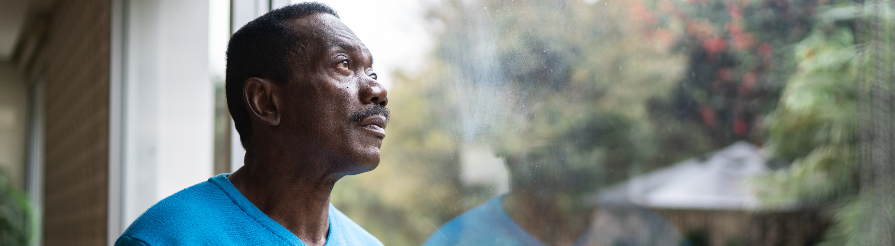 Older adult looking out of a window